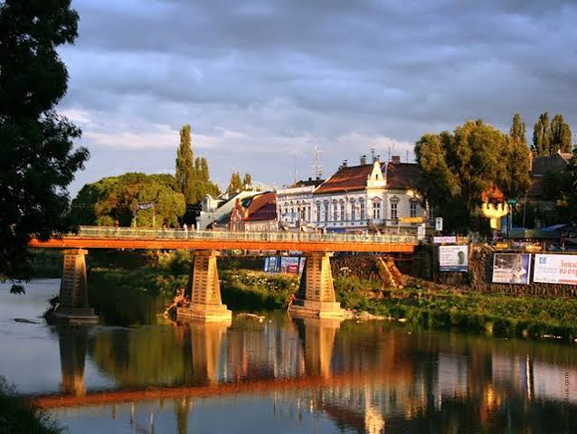 Центр Ужгорода; пішохідний міст при вечірньому світлі; вода в річці Уж