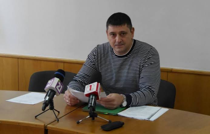 чоловік сидить за столом і дивиться в камеру; коментує підвищення тарифів на воду